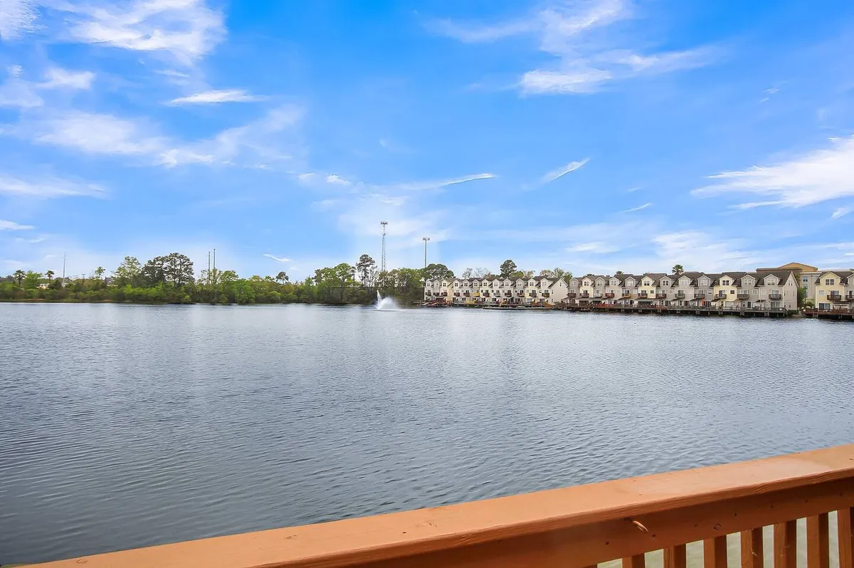 This image captures a peaceful lake scene featuring a calm water surface, a fountain, and waterfront homes in the background. The tranquil mood and scenic beauty directly represent lakeside activities and the serene environment described in the section.