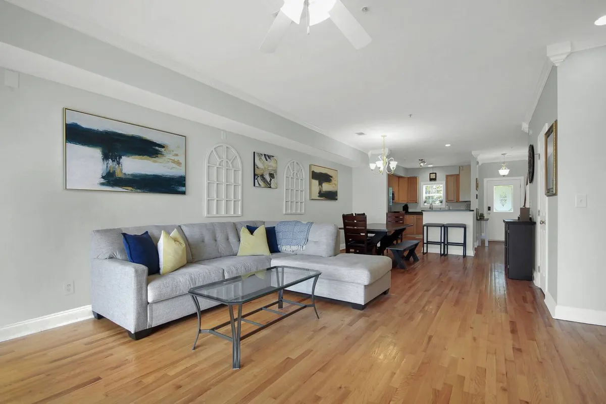 An inviting living and dining area with a comfortable sofa, a stylish dining table, and vibrant artwork. The layout encourages both social gatherings and cozy downtime, suggesting areas that can easily shift from family activities to entertaining guests.